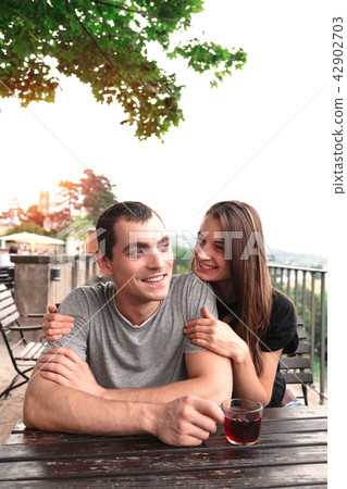 Young beautiful couple share tea at garden table 42902703