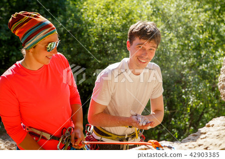 Photo of female climber in sunglasses and athlete's man with bag of talcum next to mountain Photo of female climber in sunglasses and athlete's man with bag of talcum next to mountain 42903385