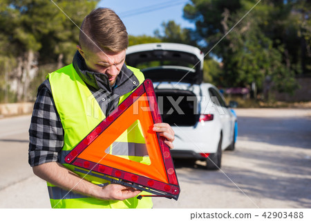 A man with a car gets an emergency sign A man with a car gets an emergency sign 42903488