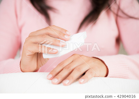 Woman cleaning her hands with a tissue. Woman cleaning her hands with a tissue. 42904016