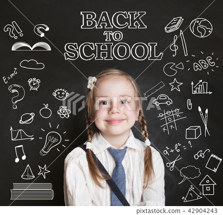 Happy pupil little girl in classroom on blackboard 42904243