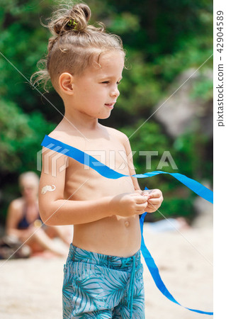 little serious boy standing on the beach 42904589