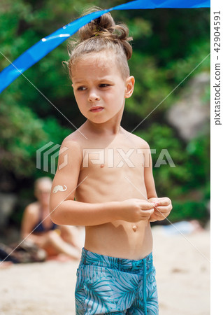 little serious boy standing on the beach 42904591