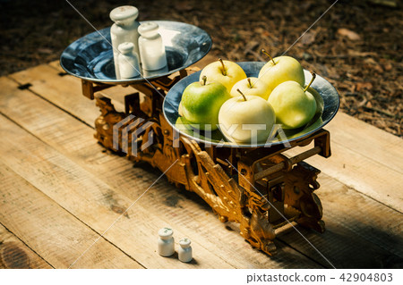 old scales painted gold with weights and green apples old scales painted gold with weights and green apples 42904803
