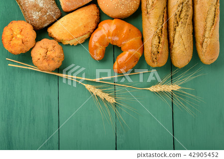 Fresh bread and ears wheat on wooden background. 42905452