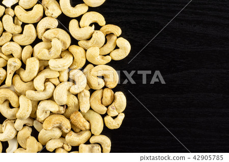 Raw cashew nut on black wood Raw cashew nut on black wood 42905785