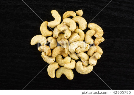 Raw cashew nut on black wood Raw cashew nut on black wood 42905790