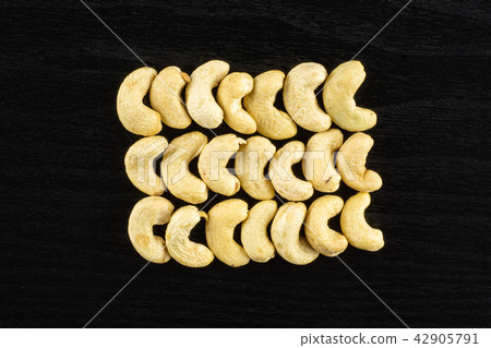 Raw cashew nut on black wood 42905791