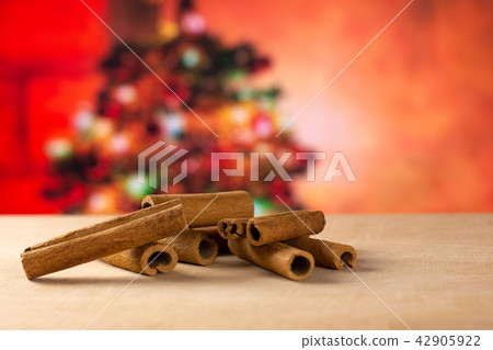 Dry brown cinamon stick with christmas tree behind Dry brown cinamon stick with christmas tree behind 42905922