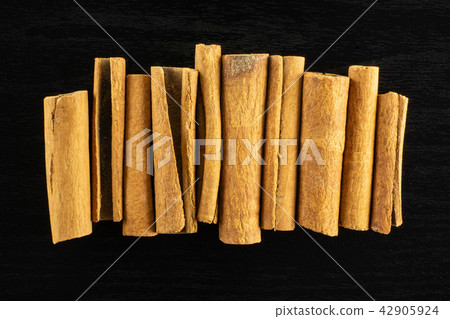 Dry brown cinnamon stick on black wood Dry brown cinnamon stick on black wood 42905924