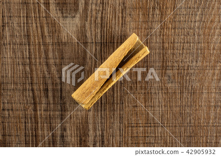 Dry brown cinnamon stick on brown wood Dry brown cinnamon stick on brown wood 42905932