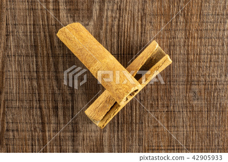 Dry brown cinnamon stick on brown wood Dry brown cinnamon stick on brown wood 42905933