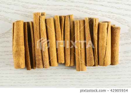 Dry brown cinnamon stick with field behind Dry brown cinnamon stick with field behind 42905934
