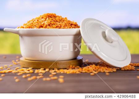 Raw red lentils with field behind Raw red lentils with field behind 42906488