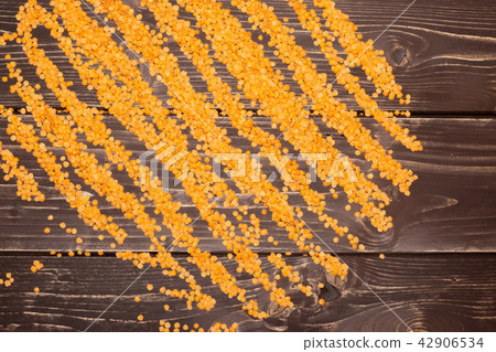 Raw red lentils on brown wood Raw red lentils on brown wood 42906534