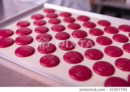 Close up of baking pan covering with parchment paper and macaroons 42907799