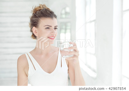 Portrait of a beautiful young woman drinking water Portrait of a beautiful young woman drinking water 42907854