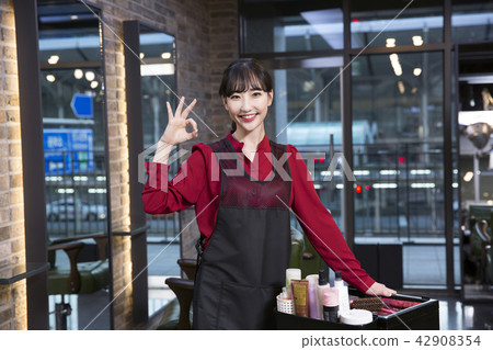 Hairdresser styling woman's hair in a salon. Korean beauty stock photo. 189 Hairdresser styling woman's hair in a salon. Korean beauty stock photo. 189 42908354