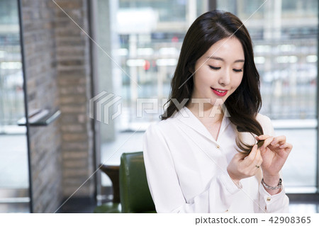 Hairdresser styling woman's hair in a salon. Korean beauty stock photo. 161 Hairdresser styling woman's hair in a salon. Korean beauty stock photo. 161 42908365