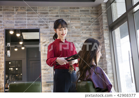 Hairdresser styling woman's hair in a salon. Korean beauty stock photo. 119 Hairdresser styling woman's hair in a salon. Korean beauty stock photo. 119 42908377