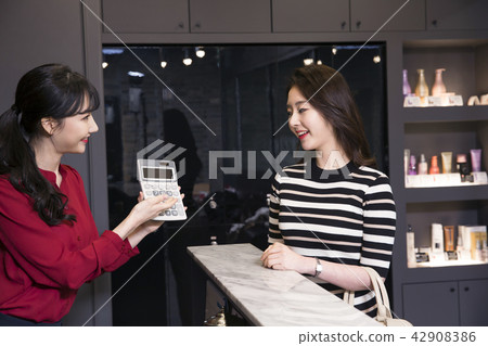 Hairdresser styling woman's hair in a salon. Korean beauty stock photo. 124 42908386