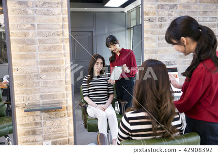 Hairdresser styling woman's hair in a salon. Korean beauty stock photo. 109 Hairdresser styling woman's hair in a salon. Korean beauty stock photo. 109 42908392