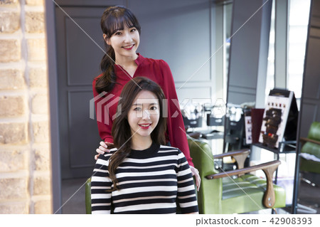 Hairdresser styling woman's hair in a salon. Korean beauty stock photo. 106 Hairdresser styling woman's hair in a salon. Korean beauty stock photo. 106 42908393