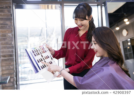 Hairdresser styling woman's hair in a salon. Korean beauty stock photo. 114 42908397
