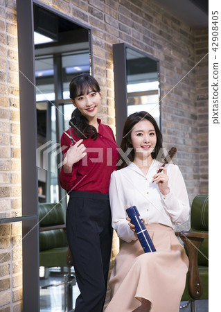 Hairdresser styling woman's hair in a salon. Korean beauty stock photo. 143 Hairdresser styling woman's hair in a salon. Korean beauty stock photo. 143 42908405