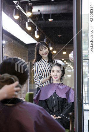 Hairdresser styling woman's hair in a salon. Korean beauty stock photo. 046 Hairdresser styling woman's hair in a salon. Korean beauty stock photo. 046 42908554