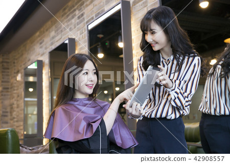 Hairdresser styling woman's hair in a salon. Korean beauty stock photo. 032 Hairdresser styling woman's hair in a salon. Korean beauty stock photo. 032 42908557