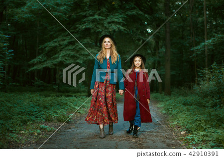 Mother and daughter are walking through  forest. 42910391
