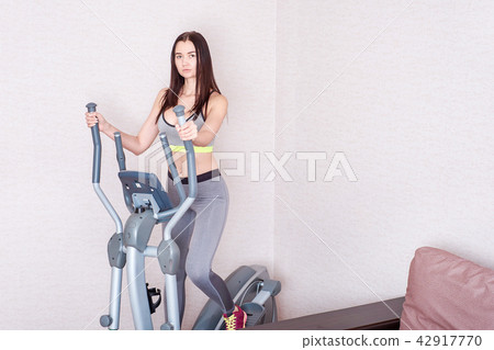 Sporty beautiful woman exercising at home to stay fit Sporty beautiful woman exercising at home to stay fit 42917770