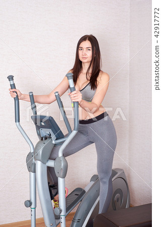 Sporty beautiful woman exercising at home to stay fit Sporty beautiful woman exercising at home to stay fit 42917772