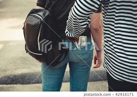 Street thief stealing money from back pocket 42918171