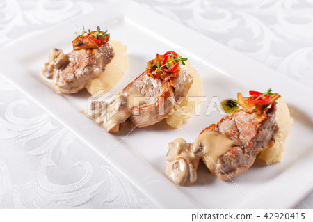 Pork Medallions with Mashed Potato and Mushrooms. Pork tenderloin on a white plate, good serving 42920415