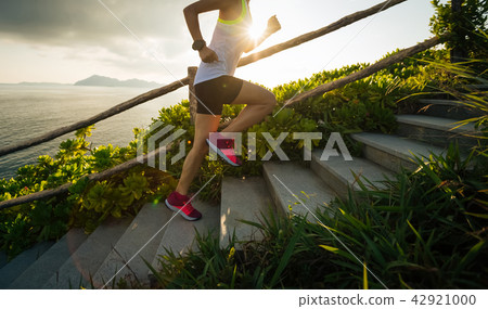 Determined woman running up on seaside Determined woman running up on seaside 42921000