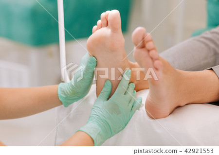 Experienced chiropodist practicing acupressure for businesswoman Experienced chiropodist practicing acupressure for businesswoman 42921553