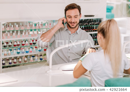 Metrosexual businessman getting manicure in beauty salon 42921664