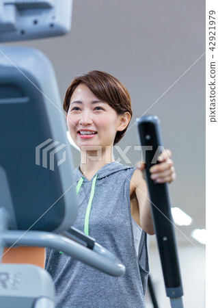 Fitness gym Young lady cross trainer 42921979