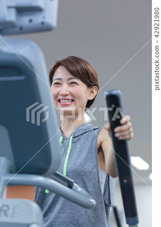 Fitness gym Young lady cross trainer 42921980