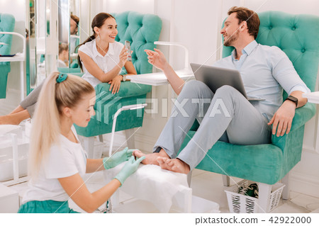 Married couple communicating while enjoying feet massage Married couple communicating while enjoying feet massage 42922000