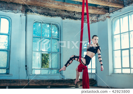Graceful gymnast performing aerial exercise at loft 42923800