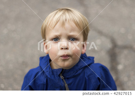 Outdoor portrait of beautiful toddler boy looking at camera 42927015