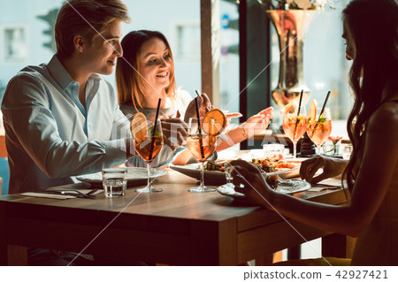 Young woman smiling during lunch with her best friends Young woman smiling during lunch with her best friends 42927421