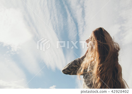 girl with long-hair against the clouds girl with long-hair against the clouds 42928402