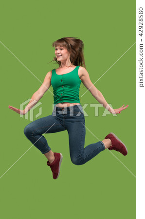 Freedom in moving. Pretty young woman jumping against orange background Freedom in moving. Pretty young woman jumping against orange background 42928580
