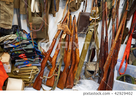 Old military uniforms and weapons in rarity store 42929402