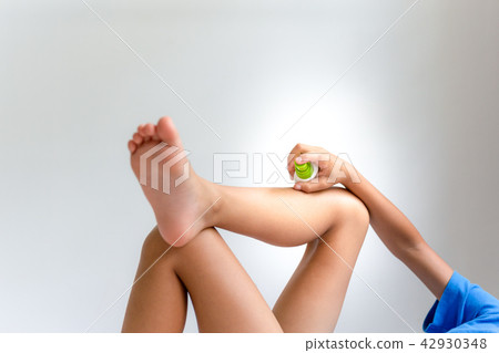 Child spraying insect repellent against mosquitos bites on his leg. Child spraying insect repellent against mosquitos bites on his leg. 42930348