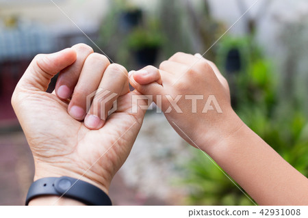 Close up Father and son hands hooking each other on little finger making promise together. 42931008